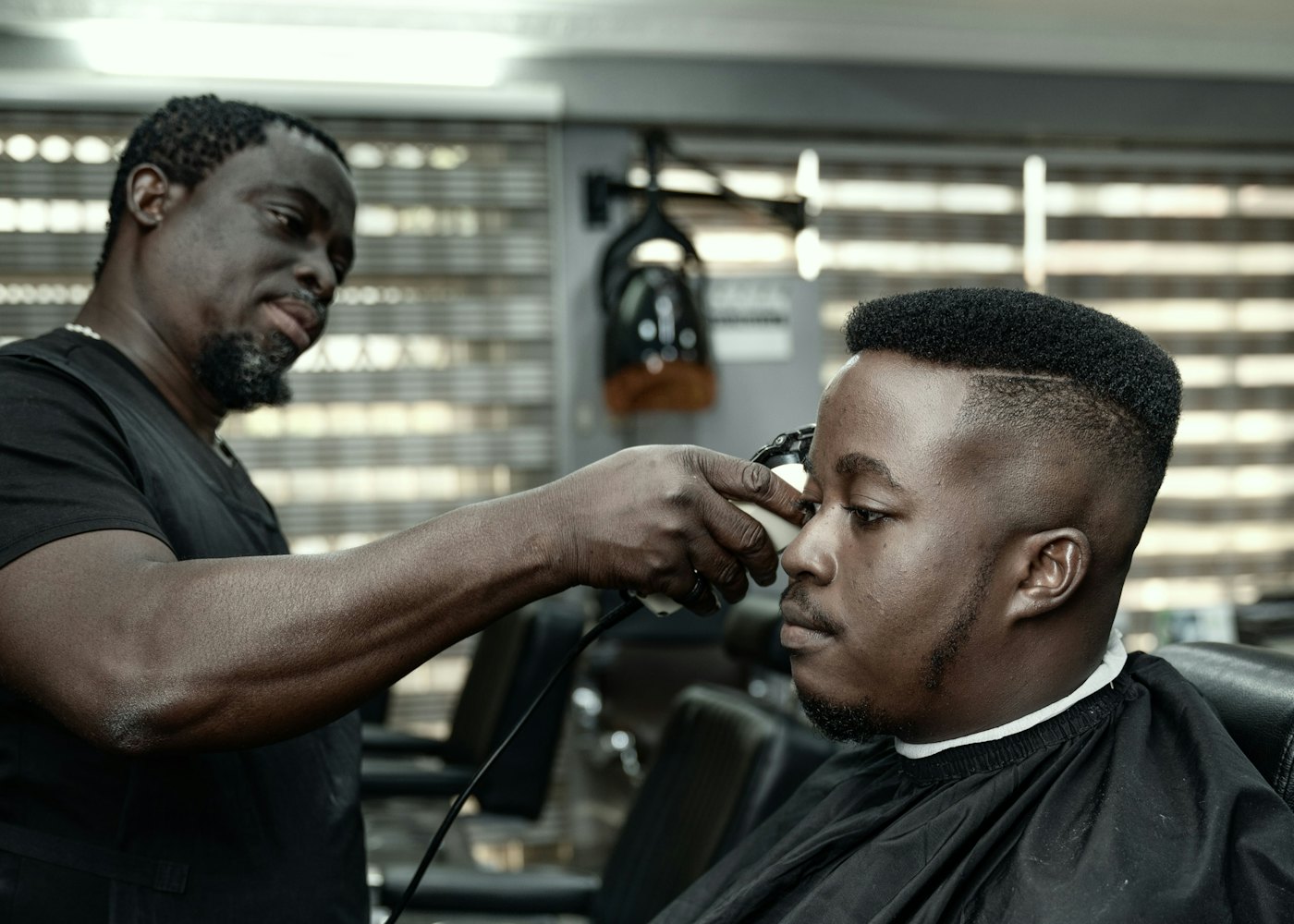 Un barbier au travail auprès d’un client dans son salon